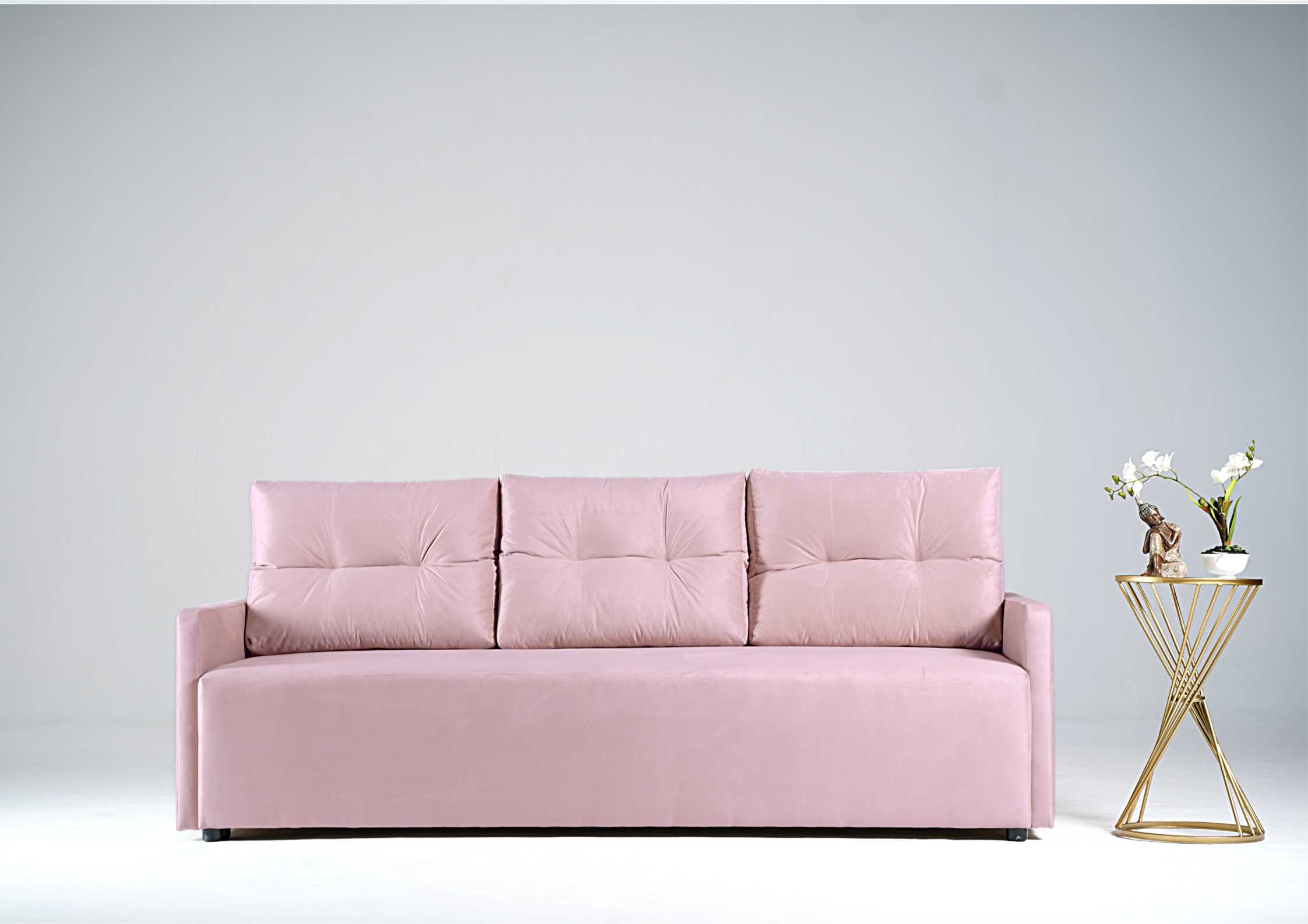 Różowa sofa z pikowanymi poduszkami